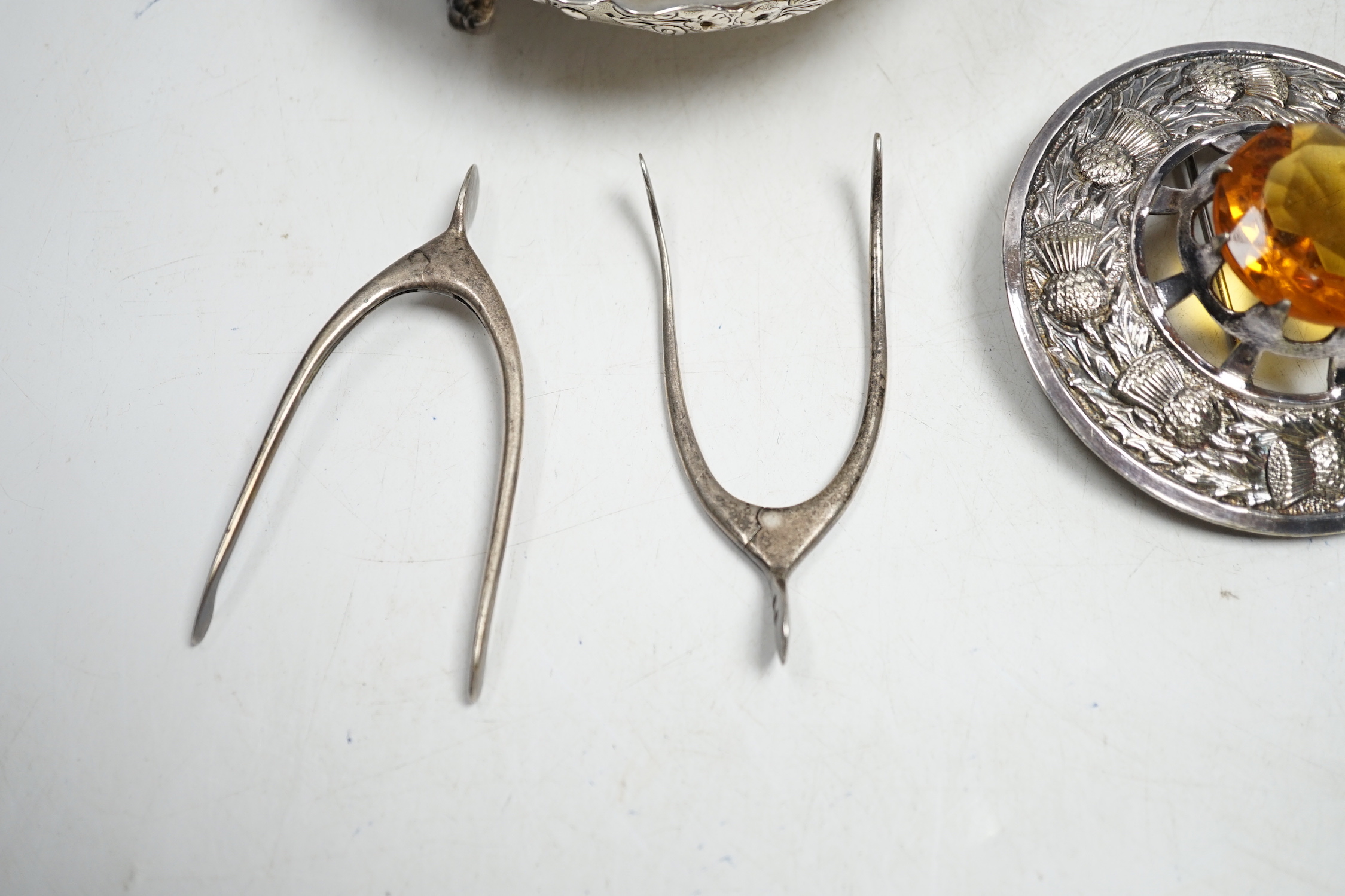 A pair of George V silver grape shears, Mappin & Webb, Sheffield, 1935, 17.2cm, four assorted pairs of early to mid 20th century silver wish bone sugar nips, a plated bowl and a brooch.